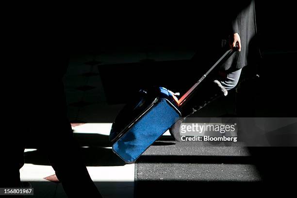 Traveler pulls a suitcase while walking out of Union Station in Washington, D.C., U.S., on Wednesday, Nov. 21, 2012. U.S. Travel during the...