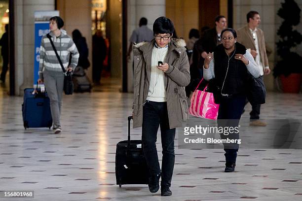 Traveler checks his phone while walking out of Union Station in Washington, D.C., U.S., on Wednesday, Nov. 21, 2012. U.S. Travel during the...