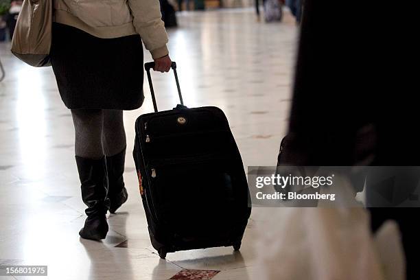 Traveler pulls a suitcase while walking out of Union Station in Washington, D.C., U.S., on Wednesday, Nov. 21, 2012. U.S. Travel during the...