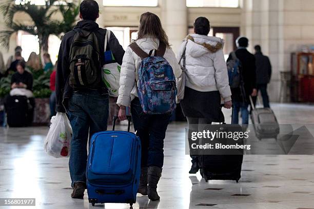 Travelers pull luggage while walking out of Union Station in Washington, D.C., U.S., on Wednesday, Nov. 21, 2012. U.S. Travel during the Thanksgiving...
