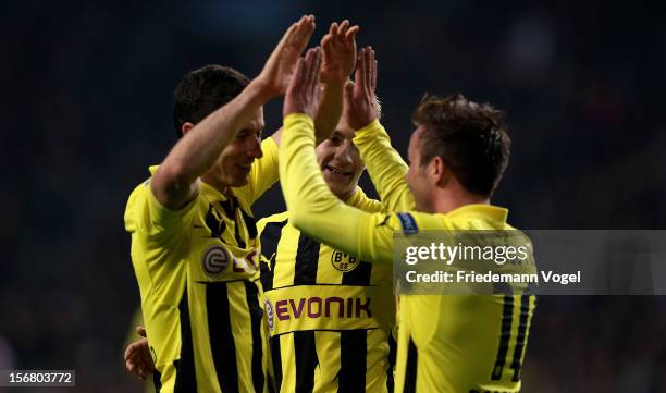 Robert Lewandowski of Dortmund celebrates scoring the fourth goal with Marco Reuss and Mario Goetze during the UEFA Champions League Group D match...