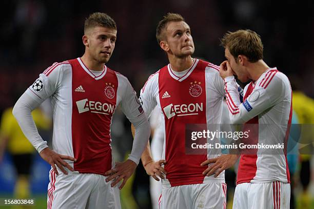 Toby Alderweireld of Amsterdam and teammates Siem de Jong and Christian Eriksen look dejected after the UEFA Champions League Group D match between...