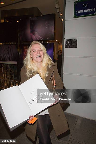 French fan shows an autograph of supermodel Kate Moss outside the 'Colette' store on November 21, 2012 in Paris, France.