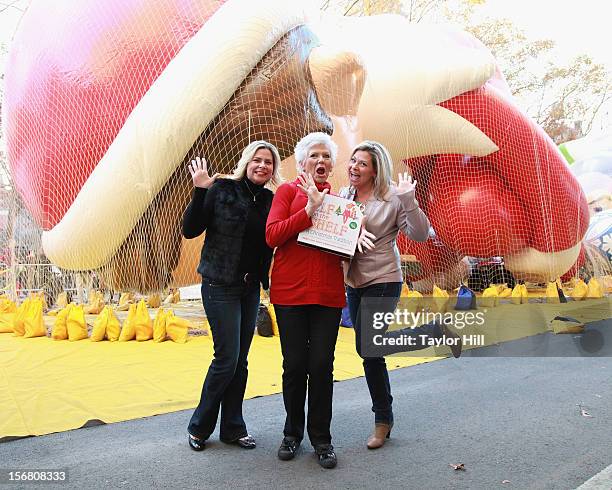 Twin sisters Chanda Bell and Christa Pitts celebrate with their mother, "The Elf on the Shelf" co-author Carol Aebersold, at the inflation of the new...