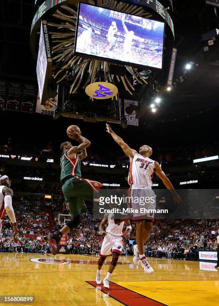 Monta Ellis of the Milwaukee Bucks shoots over Shane Battier of the Miami Heat during a game at AmericanAirlines Arena on November 21, 2012 in Miami,...