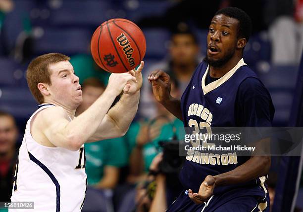 Scott Martin of the Notre Dame Fighting Irish passes the ball as Isaiah Armwood of the George Washington Colonials defends at Purcel Pavilion on...