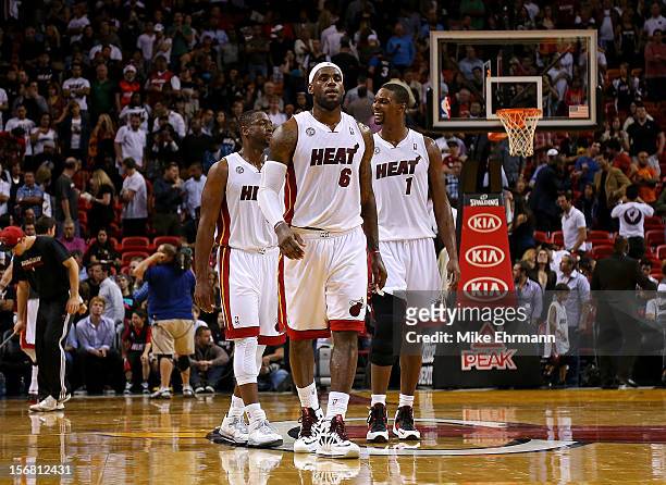 Dwyane Wade, LeBron James and Chris Bosh of the Miami Heat look on during a game against the Milwaukee Bucks at AmericanAirlines Arena on November...