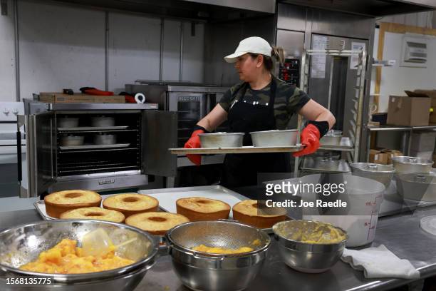 Maria Garcia, a Pearson Farm baker, makes peach cake from the fruit harvested off the trees at Pearson Farm on July 24, 2023 in Fort Valley, Georgia....