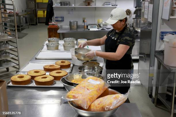 Maria Garcia, a Pearson Farm baker, makes peach cake from the fruit harvested off the trees at Pearson Farm on July 24, 2023 in Fort Valley, Georgia....