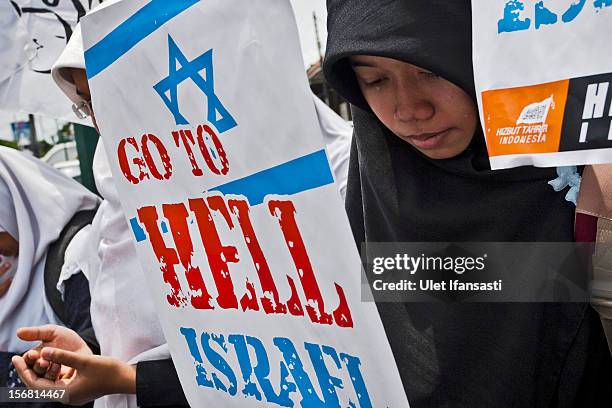 Muslim activists from Hizbut Tahrir Indonesia prays as protest during against the Israel and US governments as against Israeli air strikes on the...