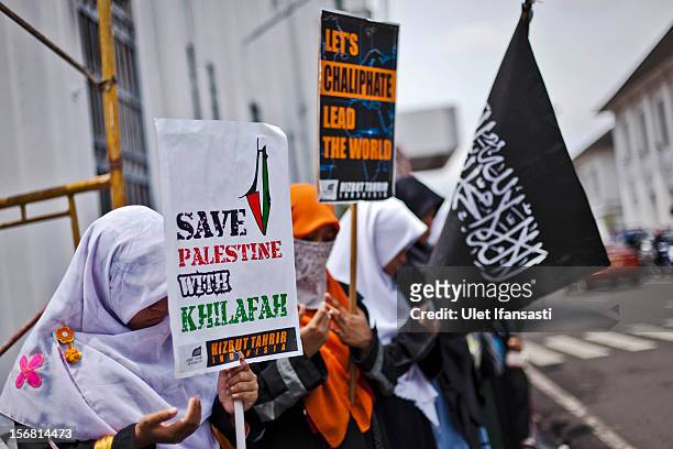 Muslim activists from Hizbut Tahrir Indonesia prays as protest during against the Israel and US governments as against Israeli air strikes on the...