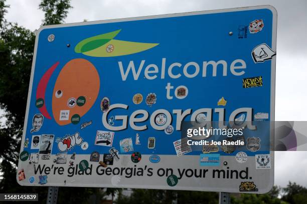 Sign with a peach on it welcomes travelers to Georgia on July 24, 2023 in Fort Valley, Georgia. Peach farmers in Georgia say that a heat wave that...