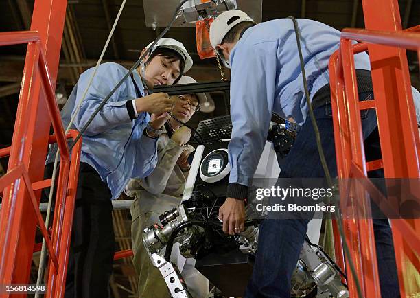 Employees move a Toshiba Corp. Tetrapod robot during a demonstration at the company's Yokohama Complex in Yokohama City, Kanagawa Prefecture, Japan,...