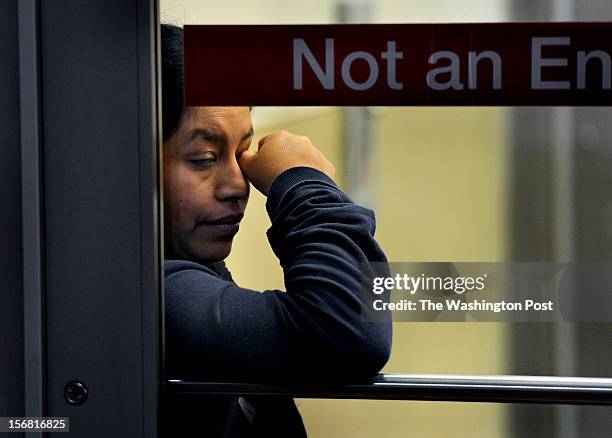 Evelin Vasquez wipes her eyes as she was very tired after shopping for a 42-inch television. She was waiting for a relative to come help her load the...