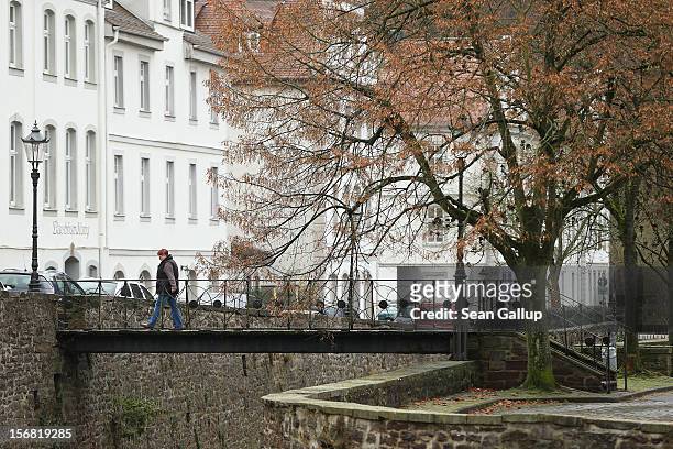 Woman crosses a pedestrian bridge on November 19, 2012 in Bad Karlshafen, Germany. Bad Karlshafen was heavily settled by Huguenot refugees in the...