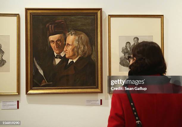 Museum administration employee, at the request of the photographer, looks at a painting of brothers Jacob and Wilhelm Grimm at the Grimm Brothers...