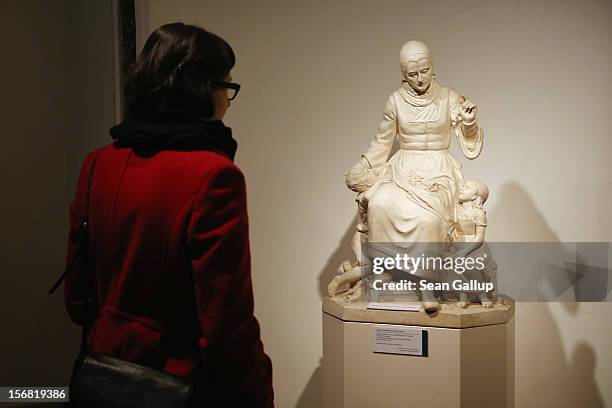 Museum administration employee, at the request of the photographer, looks at a sculpture of a woman in the likeness of Dorothea Viehmann recounting a...