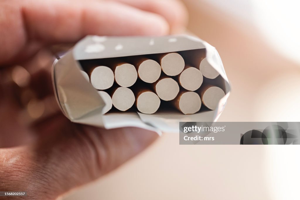Hand holding cigarette pack