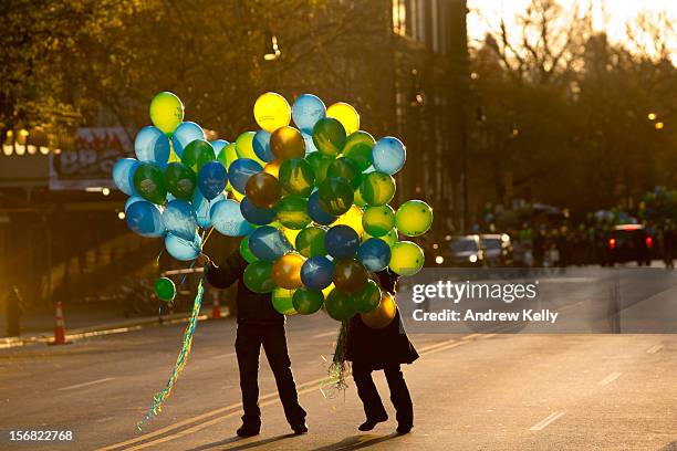 People hand out balloons on 72nd street before the commencement of the 86th Annual Macy's Thanksgiving Day Parade on November 22, 2012 in New York....