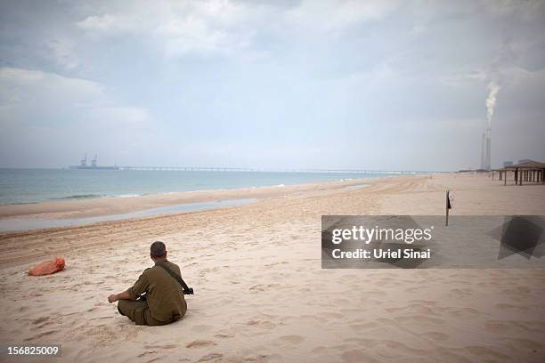 An Israeli reserve soldier sits on the beach as he prepares leaves the Gaza border area on November 22, 2012 near Israel's border with the Gaza...