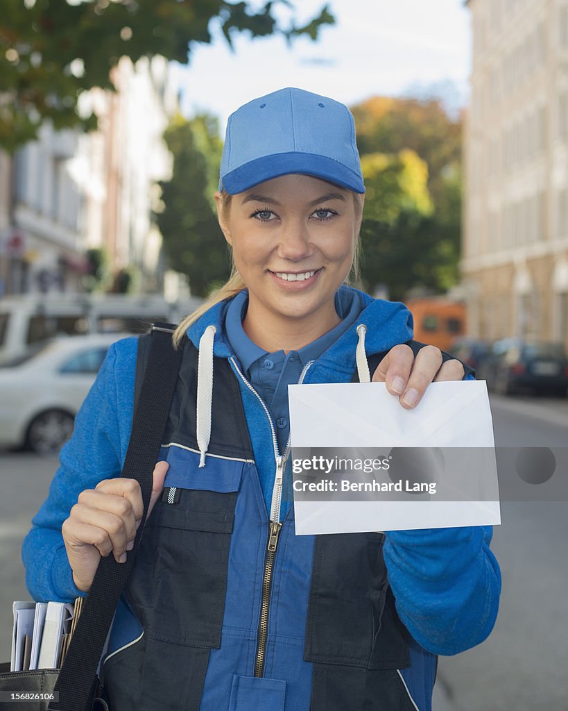 Female postal worker holding letter
