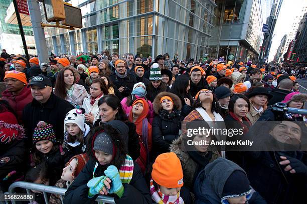 People look up as balloons make their way through the streets during the 86th Annual Macy's Thanksgiving Day Parade on November 22, 2012 in New York...