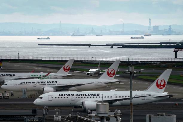 Japan Airlines passenger planes sit on the tarmac at Tokyo's Haneda Airport on August 1, 2023.