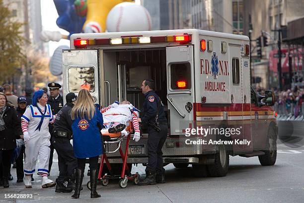 Emergency services rush to attend to a man dressed as a clown who collapsed during the 86th Annual Macy's Thanksgiving Day Parade on November 22,...
