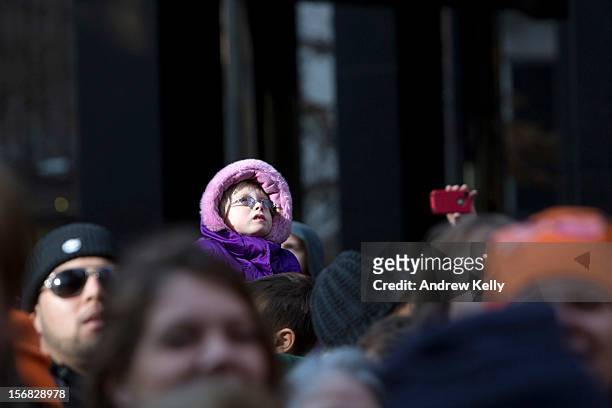 People watch as balloons make their way through the streets of Manhattan during the 86th Annual Macy's Thanksgiving Day Parade on November 22, 2012...
