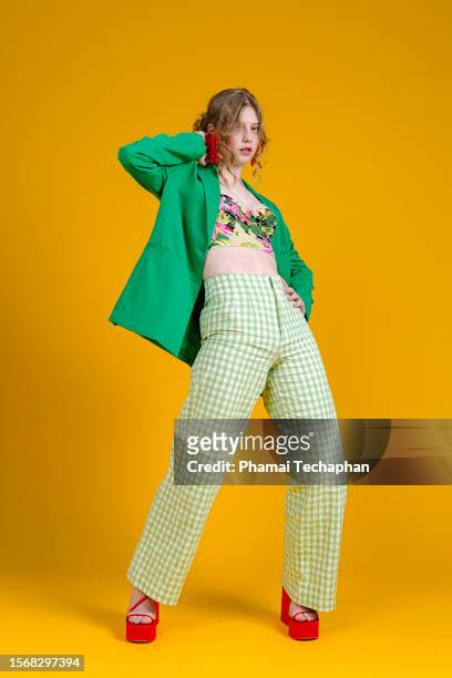 fashionable woman in front of plain background - floral pattern trousers stock pictures, royalty-free photos & images