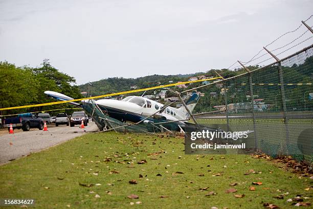 small plane crashes through fence on highway in emergency landing - propellervliegtuig stockfoto's en -beelden