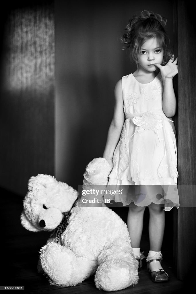 Pequena Menina bonita com um urso de peluche favoritos