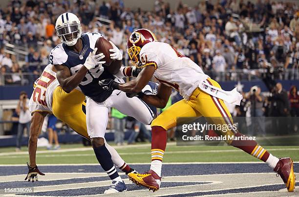 Dez Bryant of the Dallas Cowboys drops a pass in the endzone against Cedric Griffin and Madieu Williams of the Washington Redskins during a...