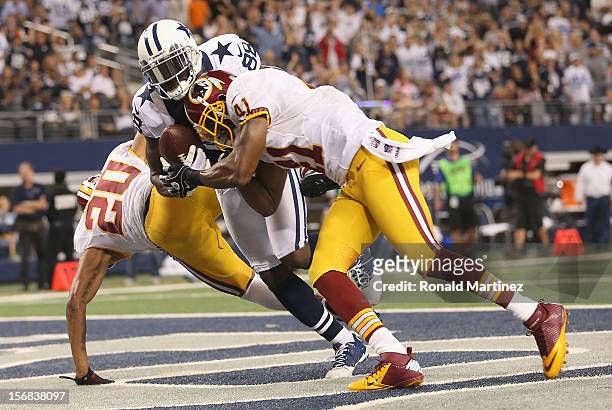 Dez Bryant of the Dallas Cowboys drops a pass in the endzone against Cedric Griffin and Madieu Williams of the Washington Redskins during a...