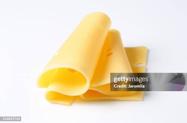 folded slices of cheese on white background - emmental cheese stock pictures, royalty-free photos & images