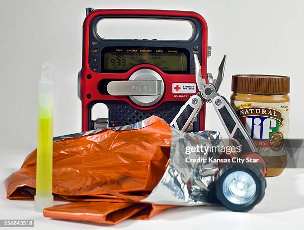 Emergencies supplies including a glow stick, an emergency blanket, a flashlight, pent butter, multi-purpose tool and radio make for a survival kit...