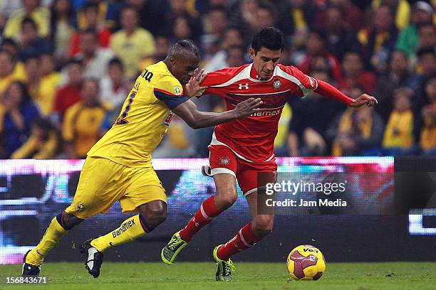 Christian Benitez of America struggles for the ball with Marvin Cabrera of Toluca during a semifinal match between America and Toluca as part of the...