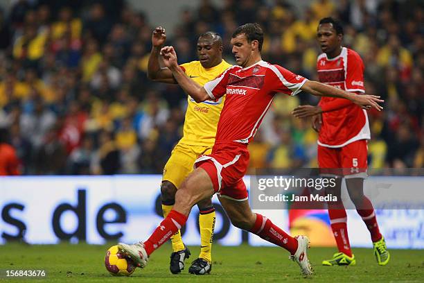 Christian Benitez of America struggles for the ball with Diego Novaretti of Toluca during a semifinal match between America and Toluca as part of the...