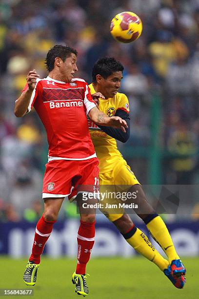 Juan Carlos Valenzuela of America struggles for the ball with Carlos Esquivel of Toluca during a semifinal match between America and Toluca as part...