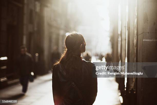 girl walking down misty street - woman from behind stock pictures, royalty-free photos & images