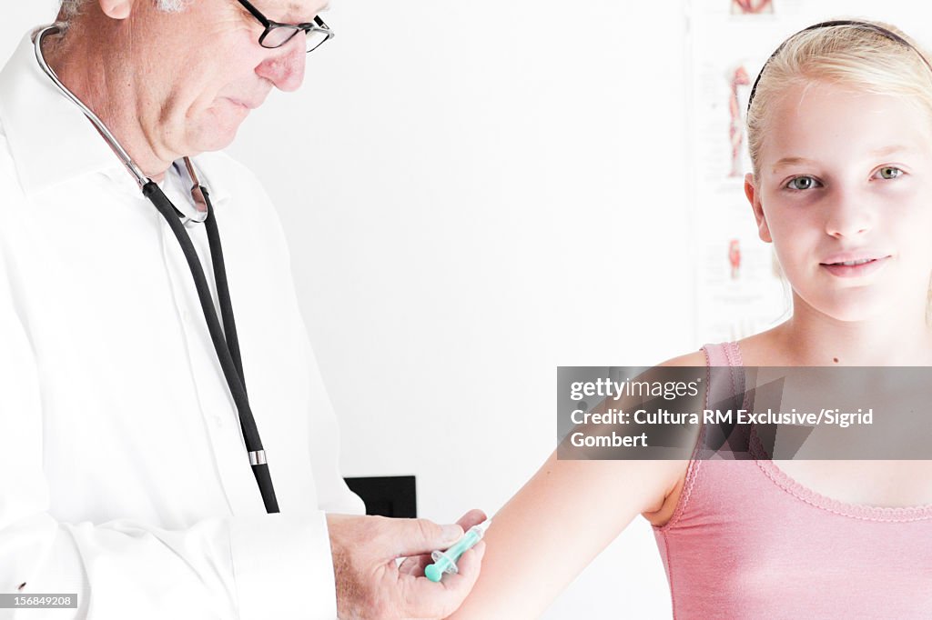 Doctor giving girl a shot