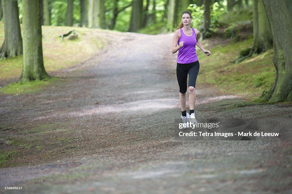 Young woman jogging in woods