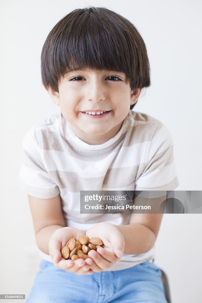 Studio Shot of young boy with almonds