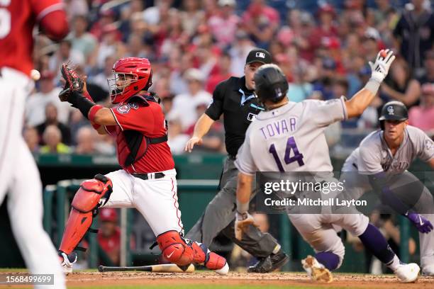 Keibert Ruiz of the Washington Nationals tags out Ezequiel Tovar of the Colorado Rockies running on a Randal Grichuk single in the sixth inning...