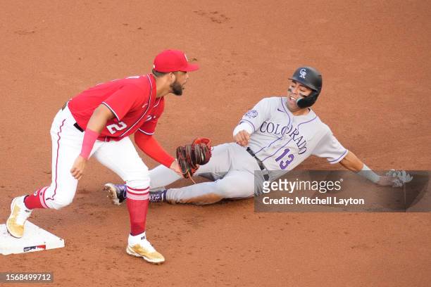 Luis Garcia of the Washington Nationals tags out Alan Trejo of the Colorado Rockies on a fielders choice in the third inning during a baseball game...