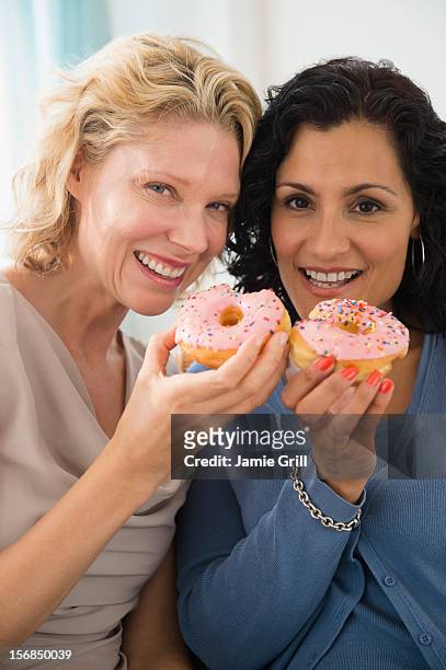 usa, new jersey, jersey city, female friends eating donuts - friends donut stock-fotos und bilder