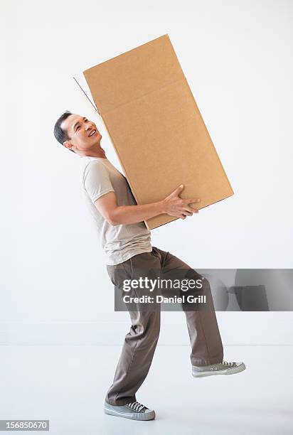 mid adult moving cardboard heavy box - carrying bildbanksfoton och bilder