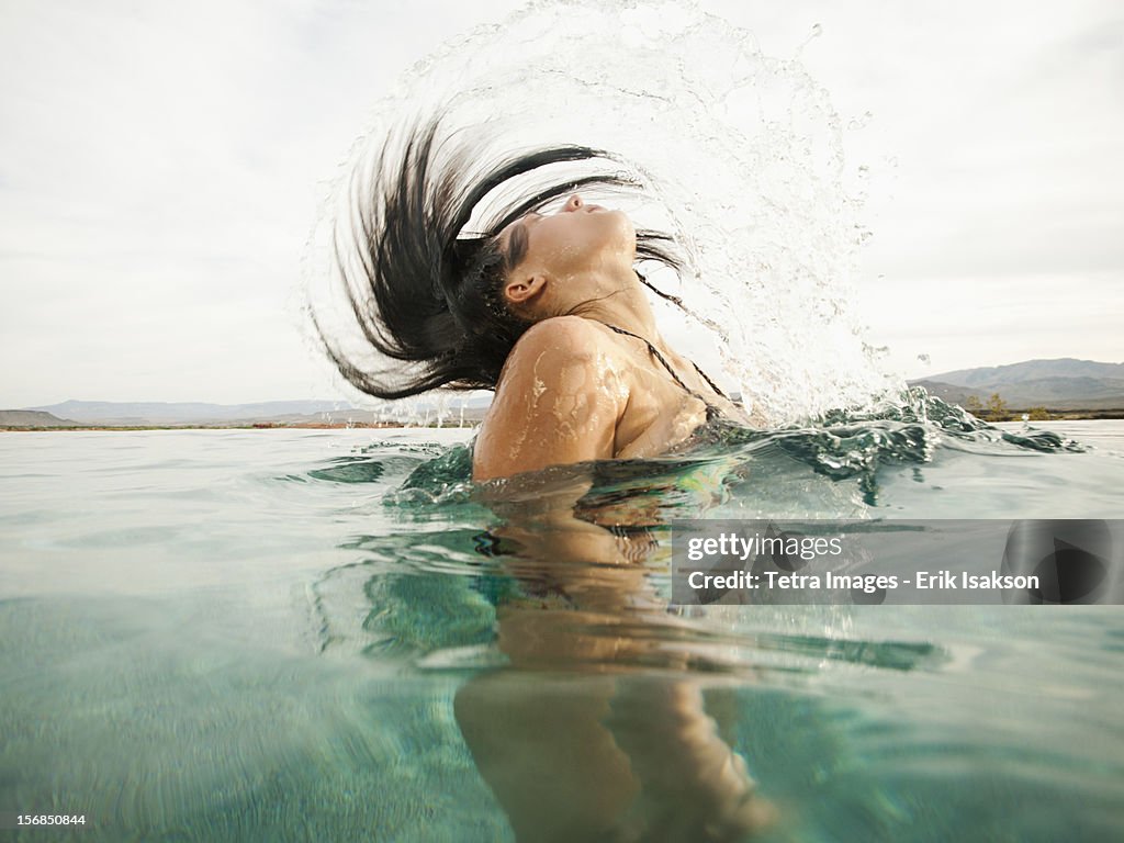 USA, Utah, St. George, Attractive young woman emerging from swimming pool