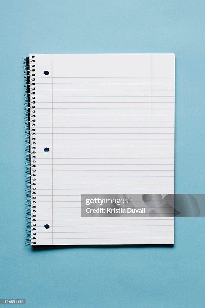 Blank spiral notebook on blue background