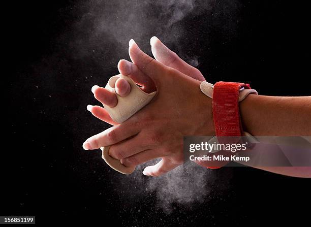 close-up of gymnast's hands with chalk floating in air around them - 女子体操 個照片及圖片檔